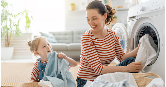 mum and child putting laundry in a washing machine