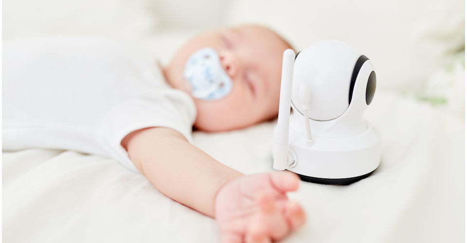 aby monitor on a nursery shelf showing live video feed of sleeping baby.