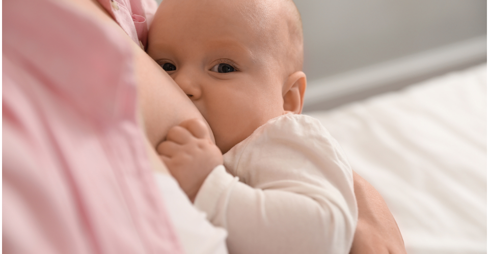 Breastfeeding mother holding newborn, symbolising safe and mindful nursing.
