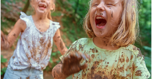 Kids splashing at in mud during outdoor messy play.