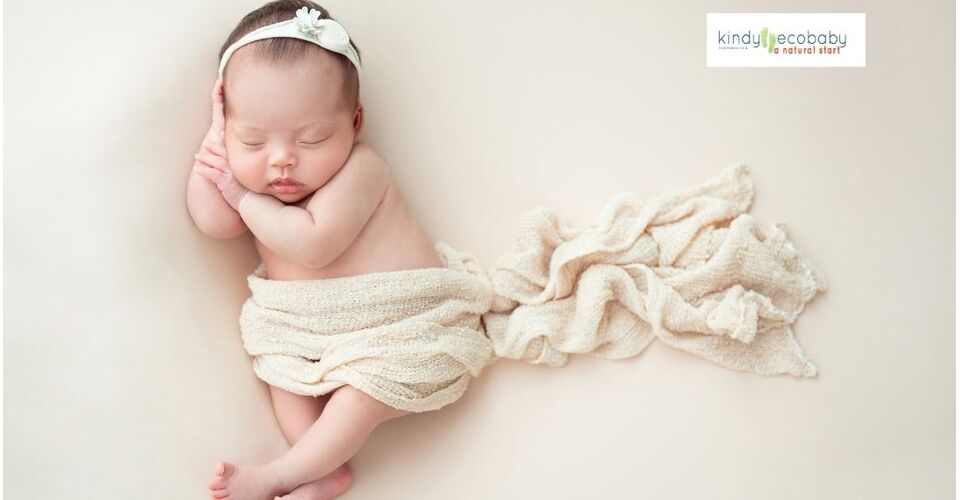 sleepng baby with headband and blanket across her