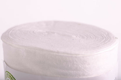 Roll of white bamboo nappy liners on a white background