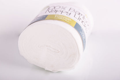 Roll of white bamboo nappy liners with a label on a light gray background